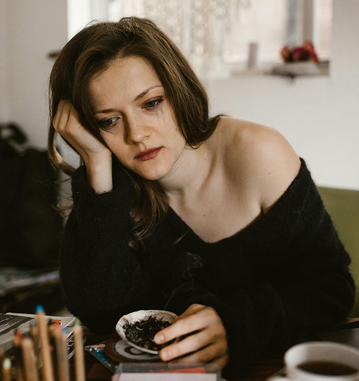 Sad woman sitting alone looking down highlighting emotional red flags in relationship
