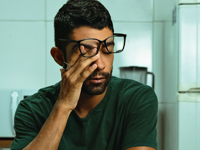 Tired man rubbing eyes symbolizing stress from red flags missed after wedding
