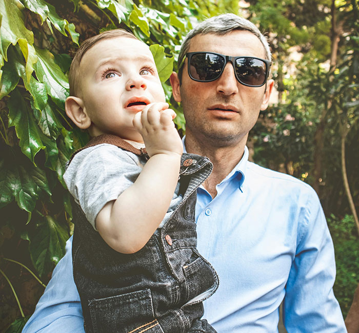 Man wearing sunglasses holding a child amid red flags women missed after the wedding