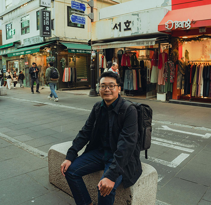 Young man sitting outside a shop, unaware of relationship red flags