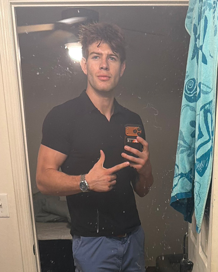Man takes mirror selfie pointing at smartphone wearing black shirt and watch Man takes mirror selfie pointing at smartphone wearing black shirt and watch