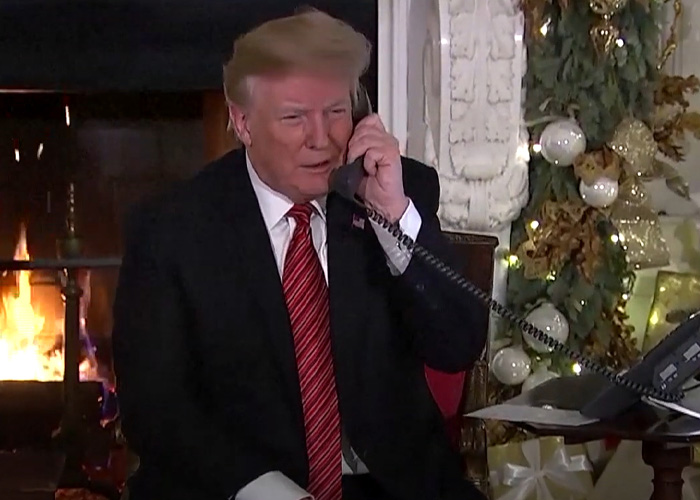 Donald Trump gaffe on a phone call by a fireplace with Christmas decorations.