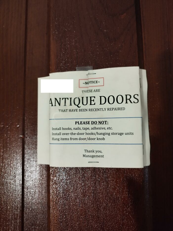A notice on an antique door restricting tenant actions, reflecting a horrible landlord's strict rules.