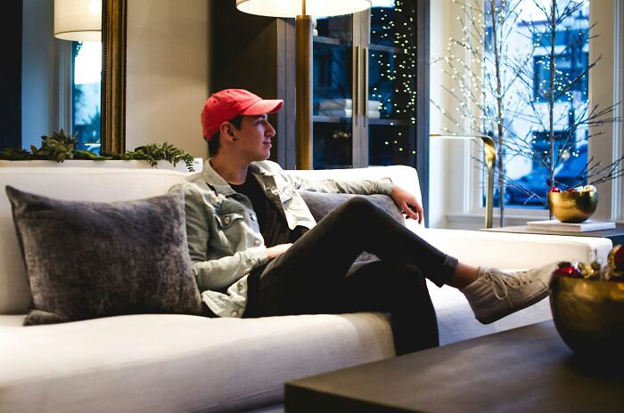 Young man relaxing on sofa enjoying home comfort luxury