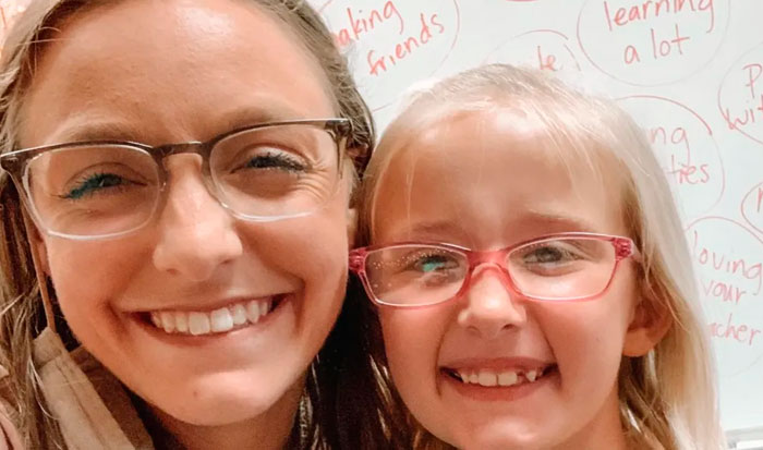 Smiling woman and child both wearing glasses, showing support and happiness