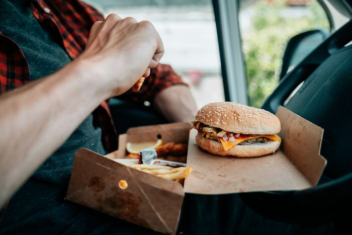 A person eating a burger and fries from a box in a car, experiencing something creepy that sounded unbelievable.