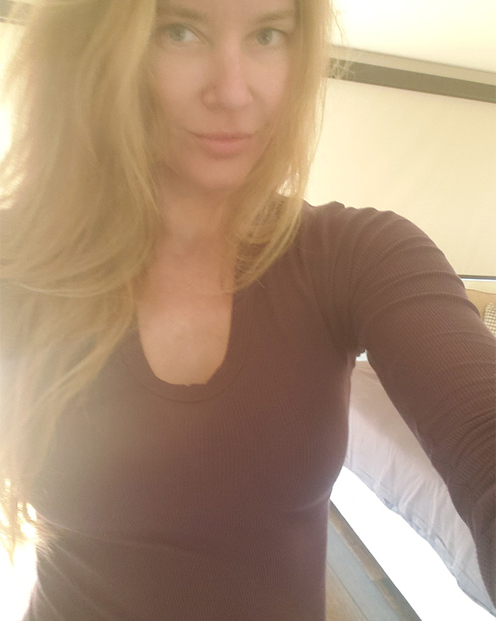 Blonde woman in brown top taking a selfie indoors Blonde woman in brown top taking a selfie indoors