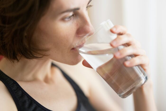 Woman drinking a glass of water highlighting clean water access