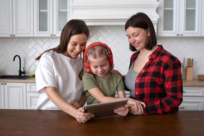 A happy DIL with her child and sister in a kitchen, sharing a moment, ending MIL confrontation. A happy DIL with her child and sister in a kitchen, sharing a moment, ending MIL confrontation.