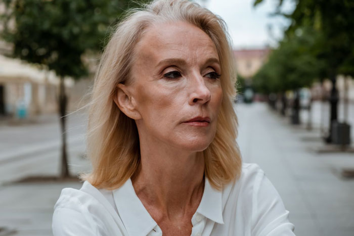 Serious woman with blonde hair; Karen shows up to stranger's home saying her son deserves it more. Serious woman with blonde hair; Karen shows up to stranger's home saying her son deserves it more.