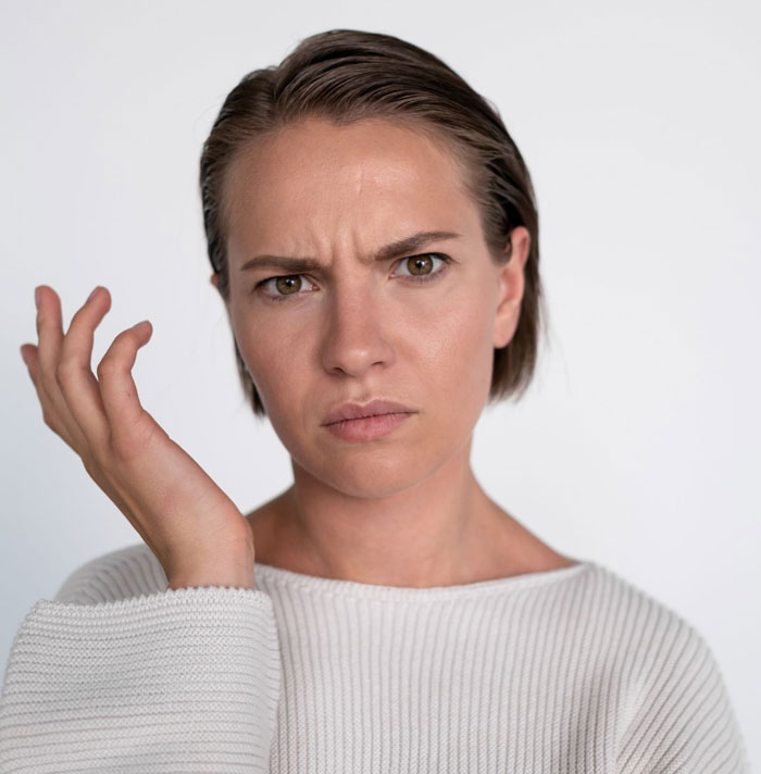 A woman with a confused and slightly annoyed expression, representing the stranger's reaction to Karen's entitlement. A woman with a confused and slightly annoyed expression, representing the stranger's reaction to Karen's entitlement.