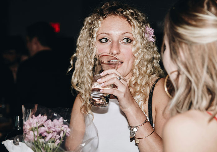 Woman drinking and talking at wedding event Woman drinking and talking at wedding event