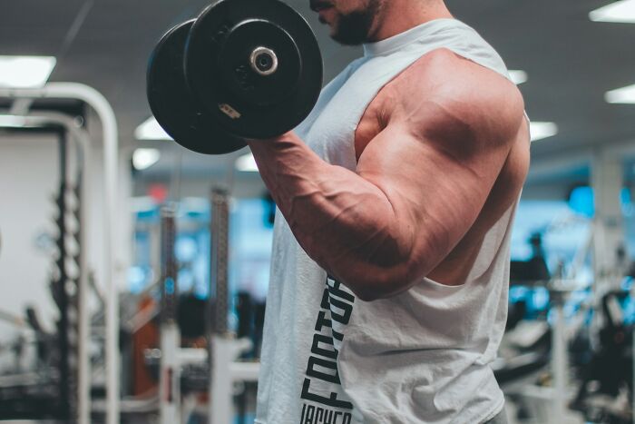 Man lifting weights, representing a healthy way to manage intense stress and burnout.
