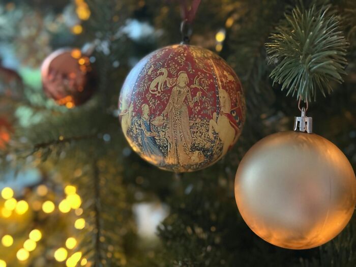 Close up of vintage Christmas tree ornaments hanging on green tree