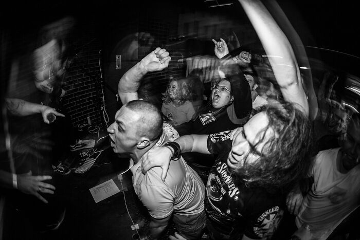 Energetic crowd enjoying a live music concert with raised fists