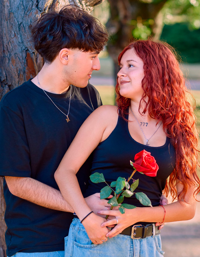Couple embracing outdoors holding a rose showing modern dating relationships