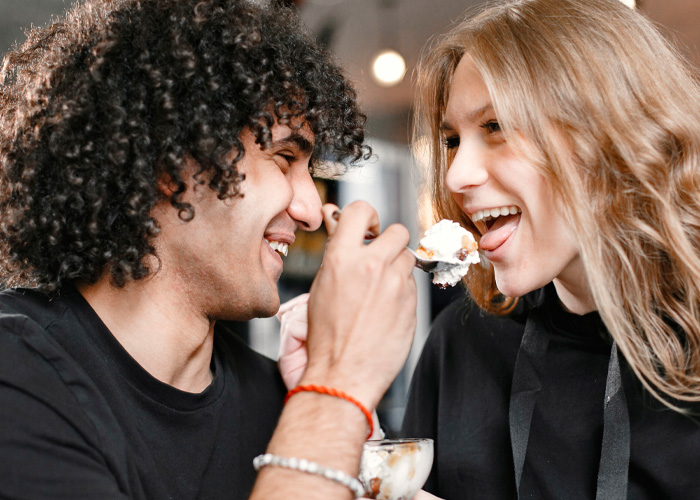 Happy couple sharing dessert illustrating spoiled pig syndrome dynamics