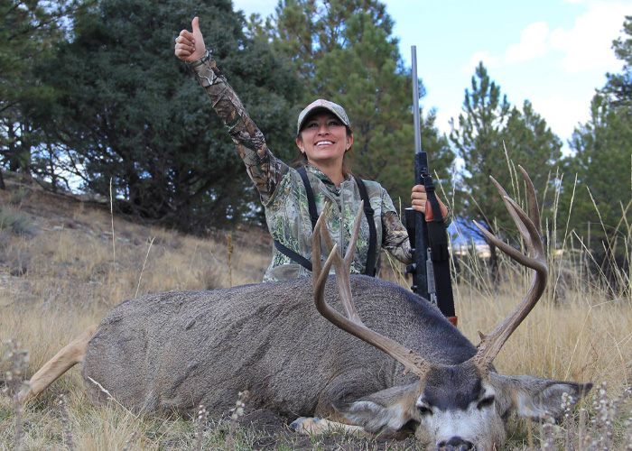 Hunter posing with large deer showing success in outdoor hunting Hunter posing with large deer showing success in outdoor hunting