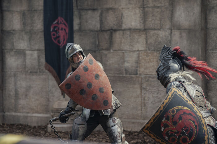 Two knights in full armor with shields fight during a House Of The Dragon scene, a disturbing moment.
