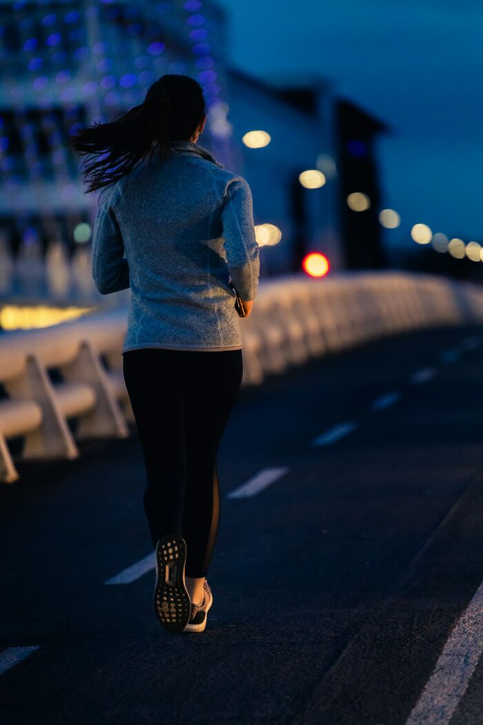 A person jogging on a road at dusk, showing healthy activity, contrasting with unserious ER visits.