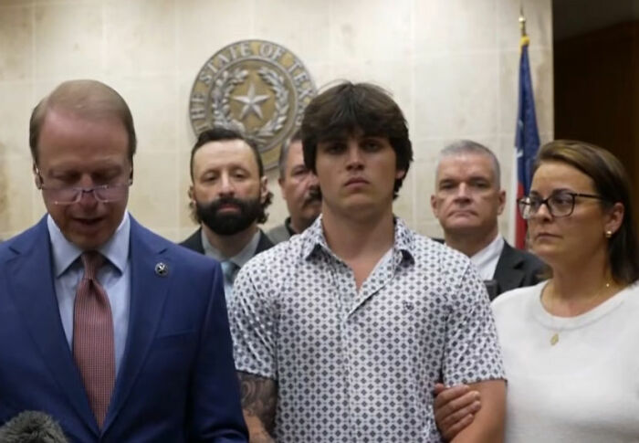 Man surrounded by people speaks during court appearance in Texas courtroom