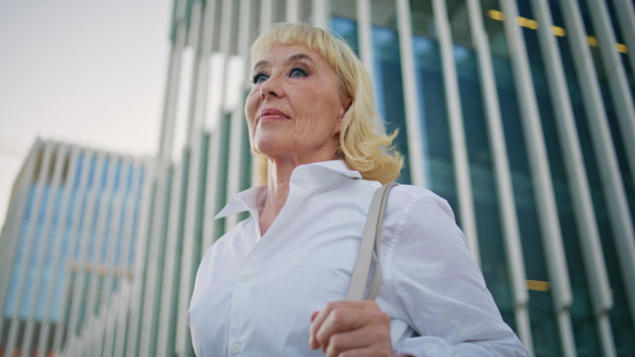 Woman standing confidently outside near tall office buildings Woman standing confidently outside near tall office buildings