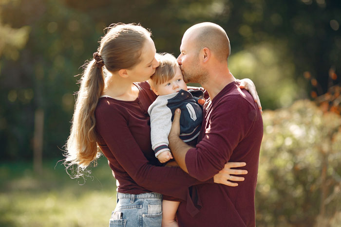 Young family with baby outdoors symbolizing family bond Young family with baby outdoors symbolizing family bond