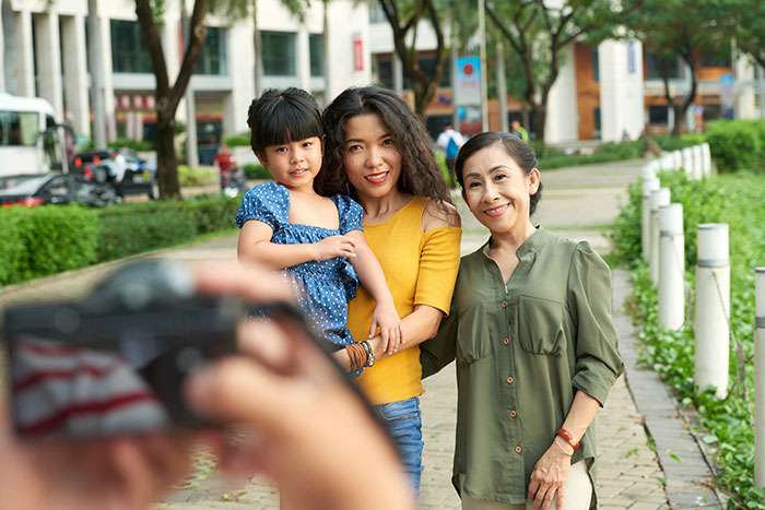 Family posing for photo in park depicting positive interactions between strangers