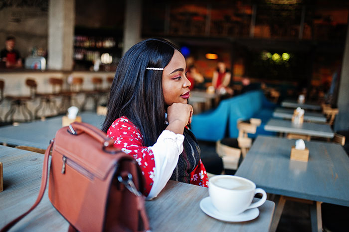 Woman in coffee shop embodying unwritten rules between strangers for a better world