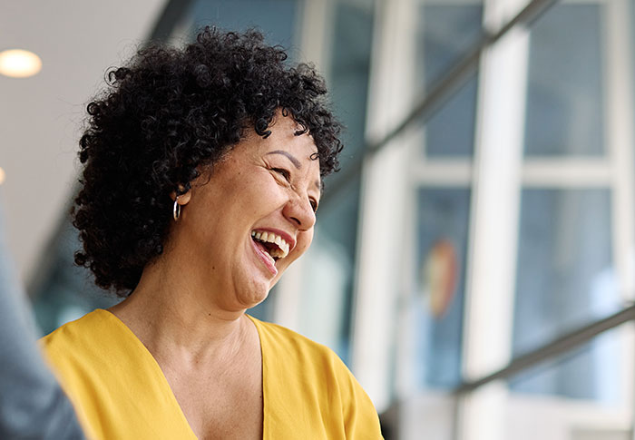 Woman laughing happily in brightly lit modern space