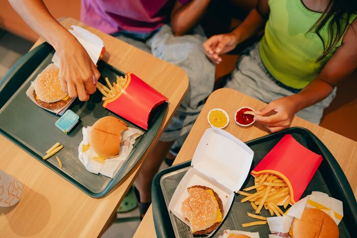 Two people eating fast food at a table, possibly illustrating a moment leading to a marriage ending.
