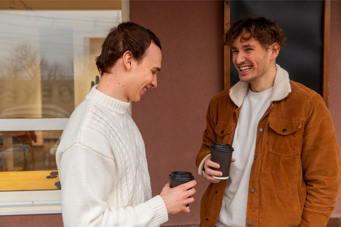 Two men, possibly a talkative fiancé and his friend, enjoying coffee and conversation, craving strangers attention. Two men, possibly a talkative fiancé and his friend, enjoying coffee and conversation, craving strangers attention.
