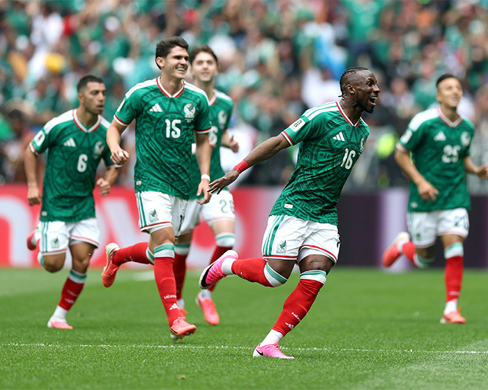 Mexican World Cup soccer players celebrating on the field in green and white uniforms. Mexican World Cup soccer players celebrating on the field in green and white uniforms.