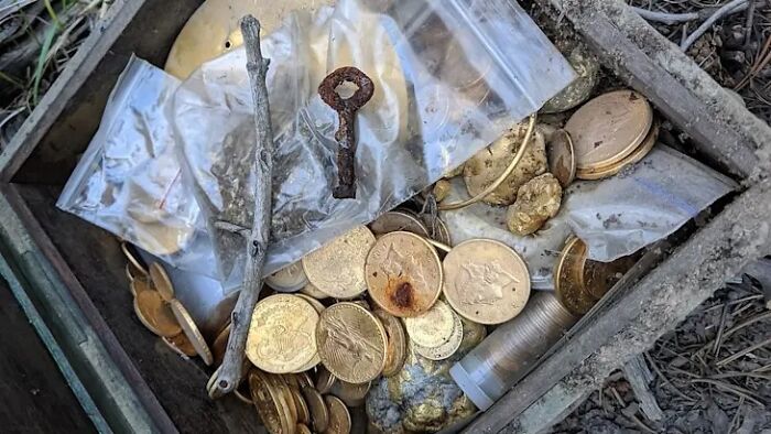 An open wooden box filled with old gold coins, keys, and nuggets, representing a solved mystery.