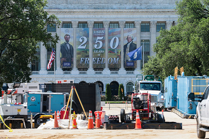 USDA building with banner celebrating 250 years of freedom and construction equipment outside