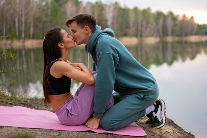 Couple kissing outdoors near water on a date Couple kissing outdoors near water on a date