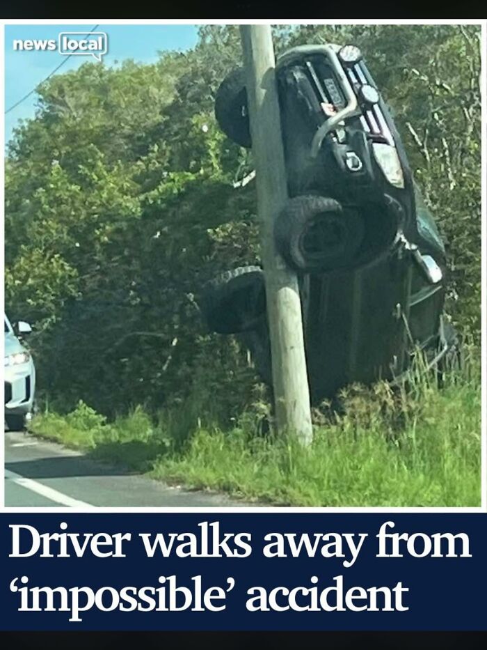Local news showing a car suspended vertically on a pole after accident