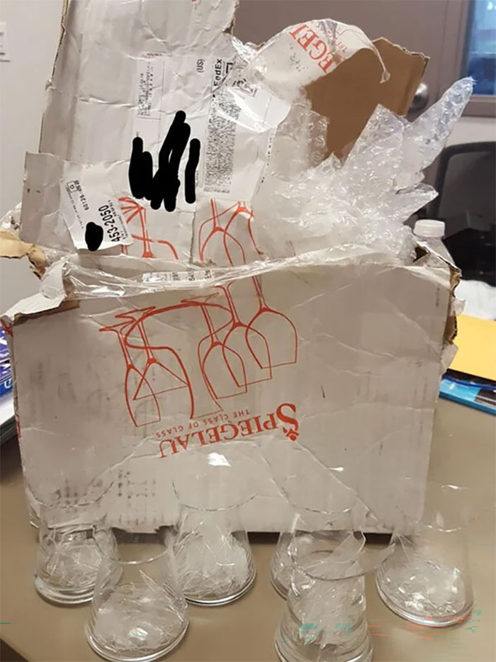 A heavily damaged box with broken glasses, evidence of a bad delivery fail.