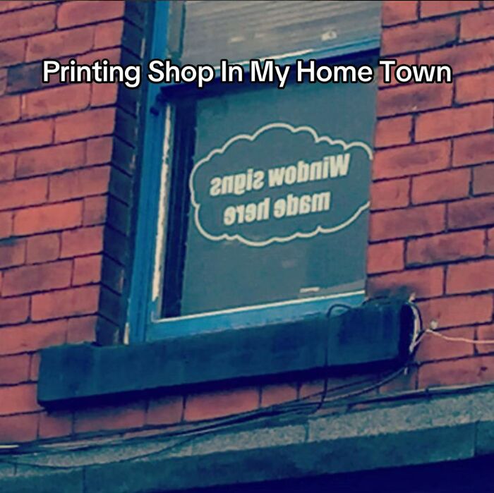 A hilariously bad design fail: a printing shop window with backward text, making it unreadable from outside.