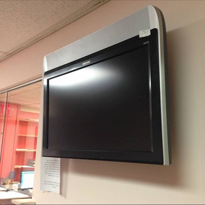 Wall-mounted TV with no visible support or proper installation
