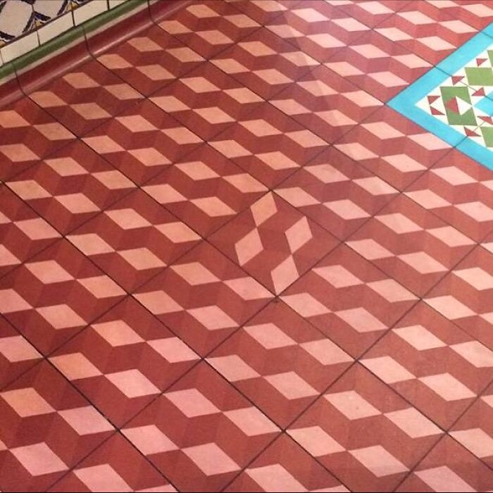 Tiled floor with misaligned geometric pattern causing optical illusion