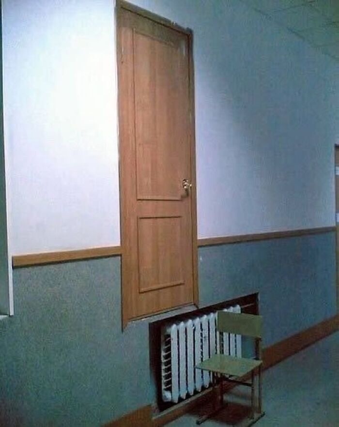 Wooden door installed high on wall above radiator and chair, a cringeworthy design fail
