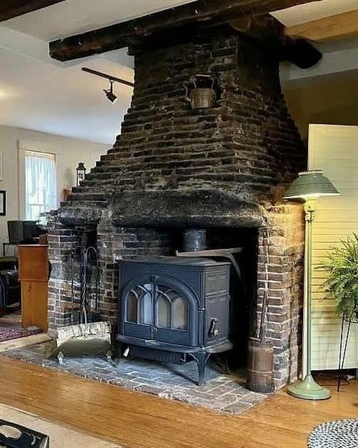 Rustic fireplace with outdated wood stove in old house interior