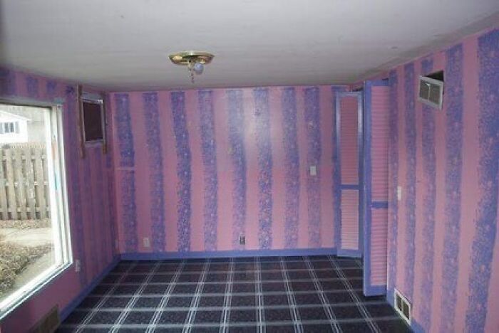 Room with mismatched plaid carpet and pink striped wallpaper design fail