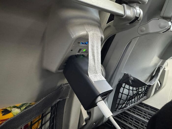 Airplane seat charger poorly taped to outlet with USB cable