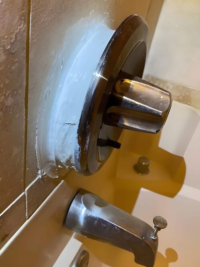 Poor bathroom design with faucet and handle misaligned on bathtub
