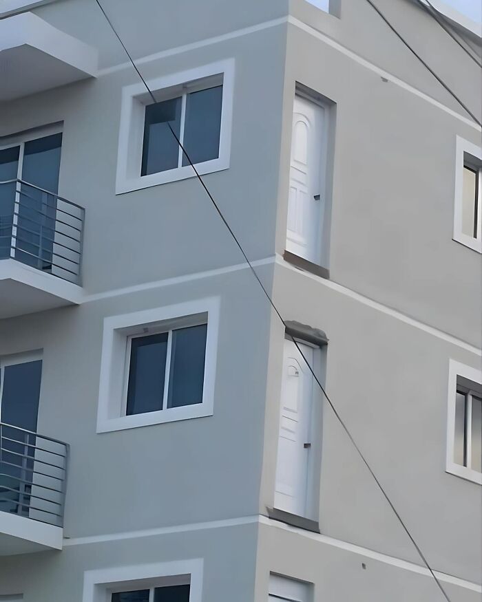 Building facade with design fail showing doors inaccessible in a high wall