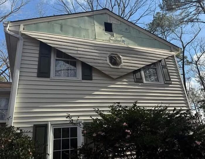 House siding with poorly installed angled window canopy