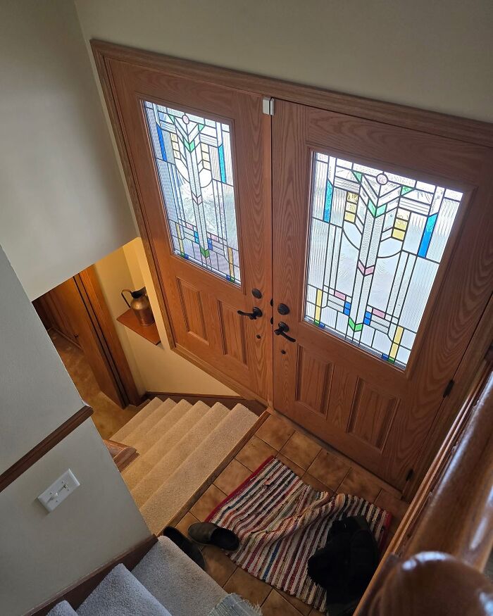 Entryway with stained glass door leading directly to stairs design fail