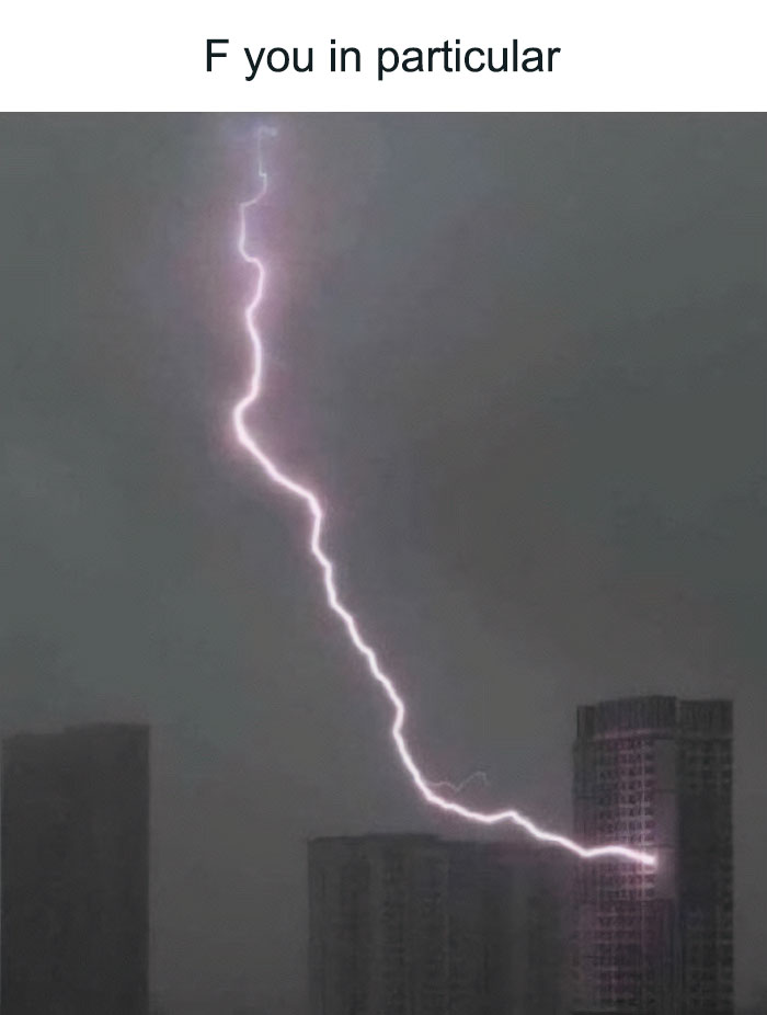 A dramatic lightning bolt striking a tall building during a dark storm, an example of savage comments about nature.